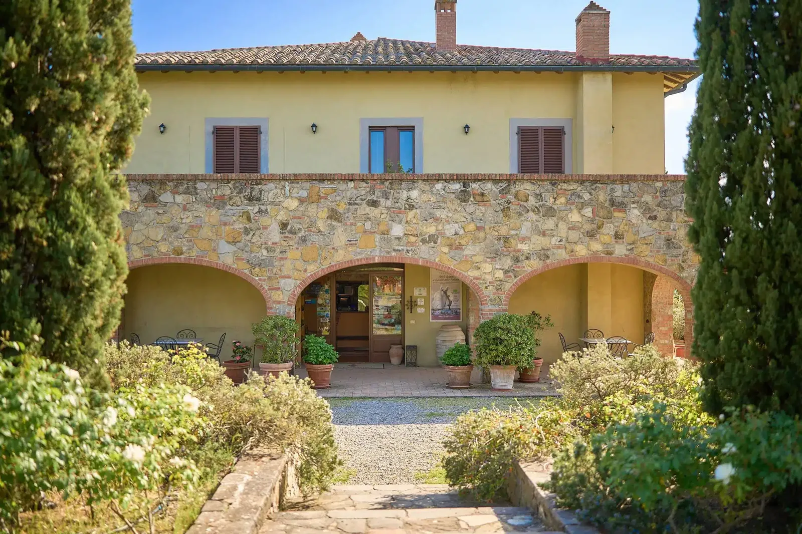 casale in pietra serena immerso nei vigneti autunnali